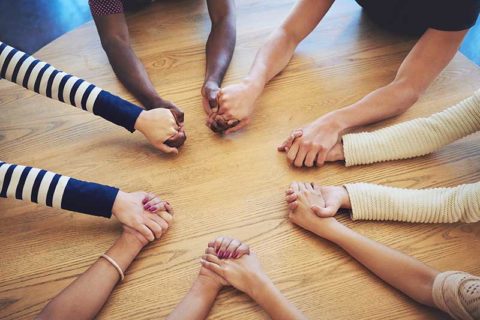 People on desk holding each others hands