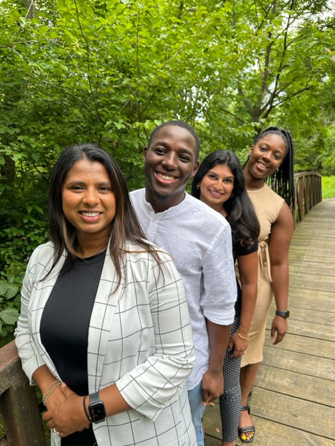 four people smiling
